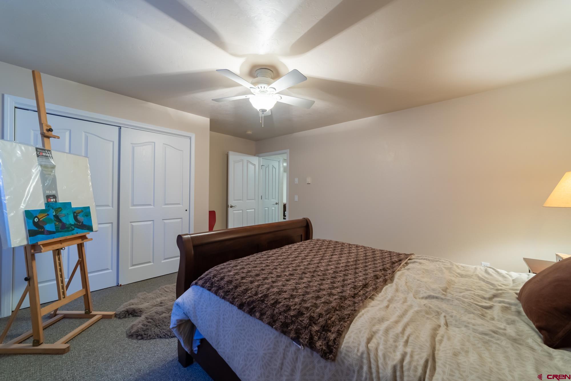 68041 Ute Vly Drive Montrose, CO 81403 - Photo 29 of 35 a bedroom with a bed and a chandelier