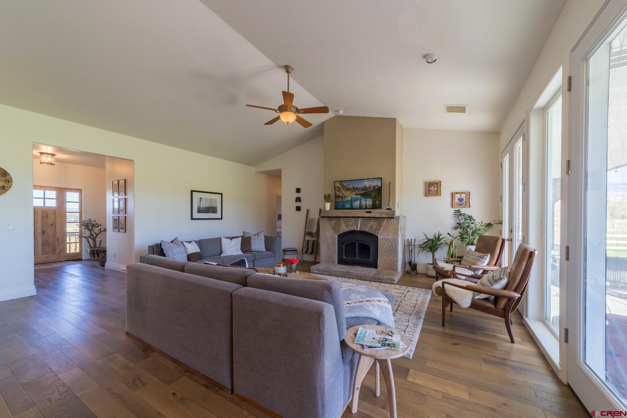 68041 Ute Vly Drive Montrose, CO 81403 - Photo 7 of 35 a living room with furniture a fireplace and wooden floor