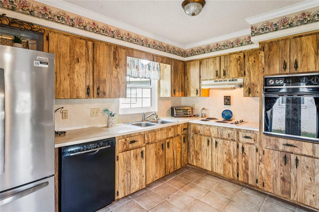 6709 Timbercove Lane, Unit 6709 New Port Richey, FL 34653 - Photo 11 of 52 a kitchen with stainless steel appliances granite countertop a refrigerator and a sink