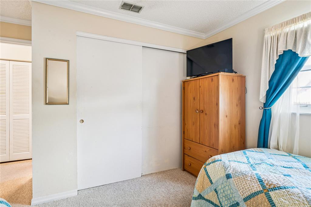 6709 Timbercove Lane, Unit 6709 New Port Richey, FL 34653 - Photo 25 of 52 a bedroom with a bed and a mirror