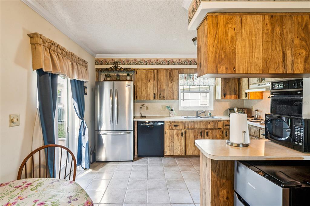 6709 Timbercove Lane, Unit 6709 New Port Richey, FL 34653 - Photo 10 of 52 a kitchen with a refrigerator and a sink