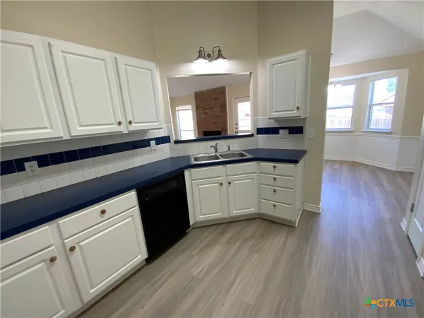 a kitchen with granite countertop white cabinets and white appliances