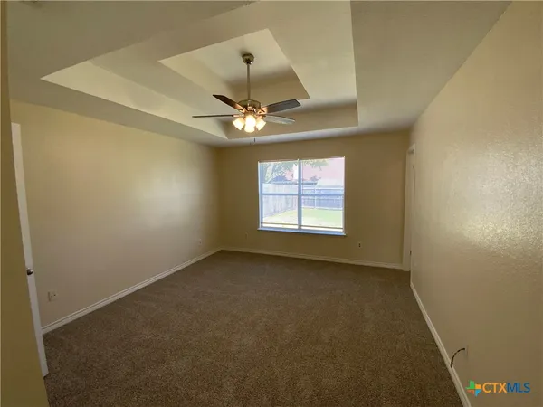 an empty room with windows and fan