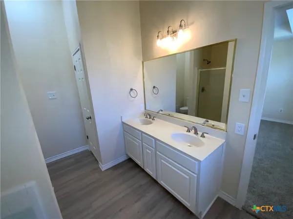 a bathroom with a double vanity sink and mirror