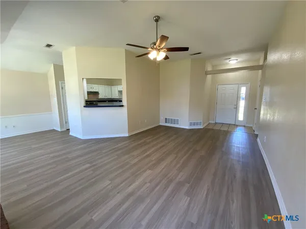a view of a kitchen with wooden floor and a kitchen space
