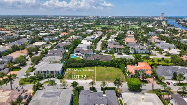 an aerial view of a city with lots of residential buildings ocean and mountain view in back