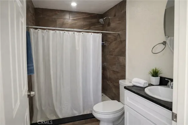a bathroom with a granite countertop sink toilet and shower