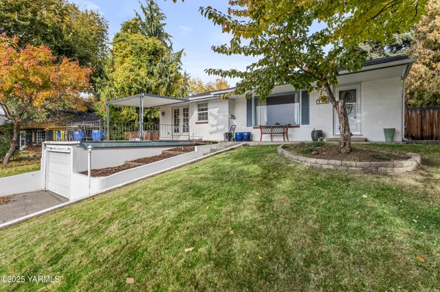 a view of a house with backyard and sitting area
