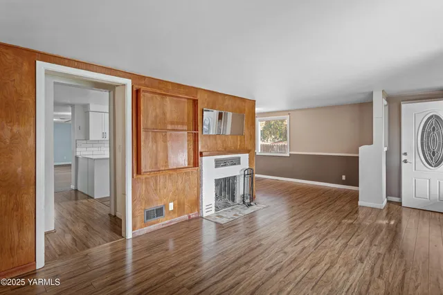 a living room with a wooden floor and a fireplace