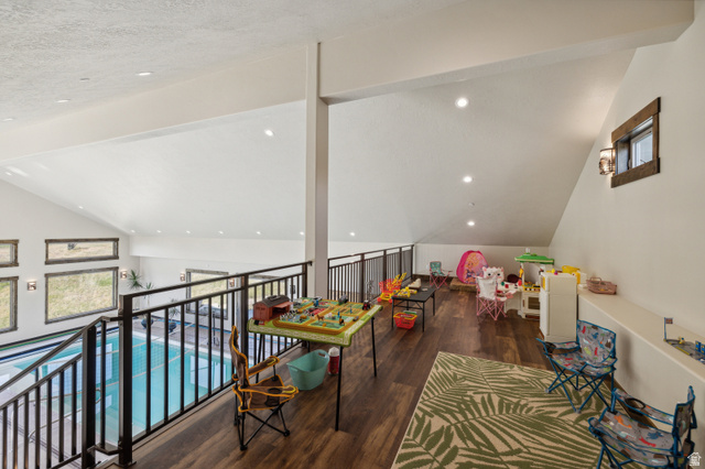 6117 North Rocky Ridge Road Peoa, UT 84061 - Photo 20 of 82 Spacious loft featuring wood-finish flooring, vaulted ceilings with recessed lighting, and a dark metal railing overlooking an indoor pool