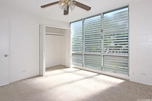 a view of an empty room with a ceiling fan
