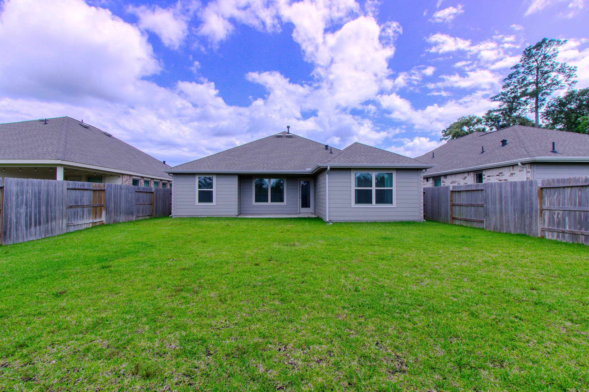 3113 Catalonion Court Conroe, TX 77301 - Photo 31 of 45 a view of a brick house with a big yard and large trees