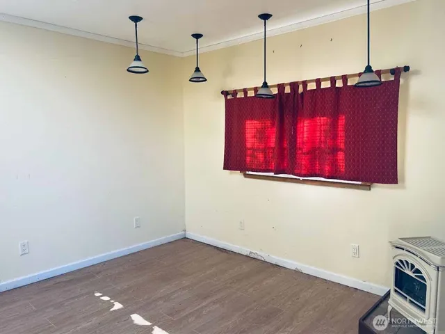 a view of a room with wooden floor and window