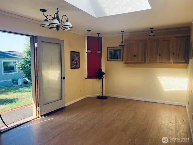 a view of a livingroom with a fireplace wooden floor and windows