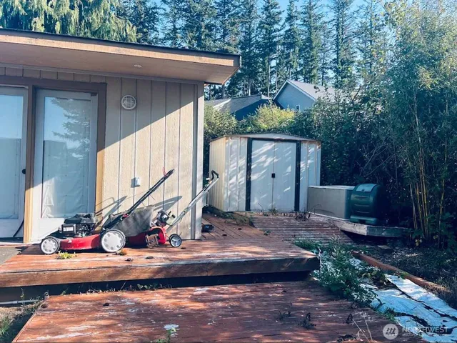 a view of house with wooden stairs and a small yard