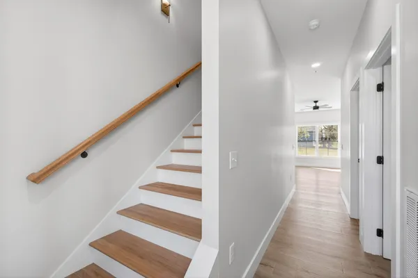 a view of a hallway with wooden floor and entryway