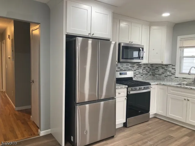 a kitchen with stainless steel appliances granite countertop a refrigerator stove and sink