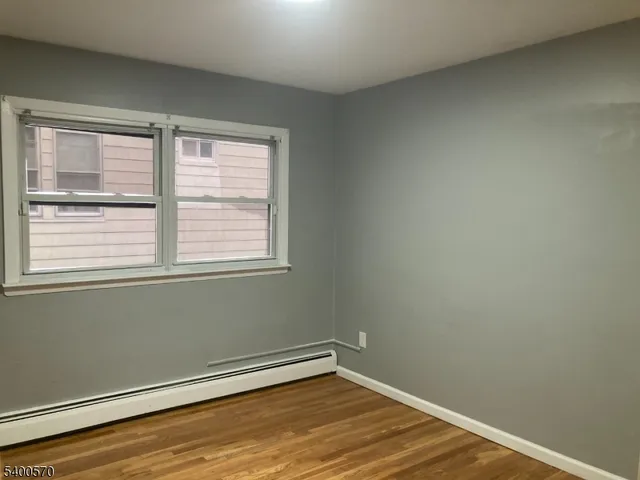 a view of a room with wooden floor and a window