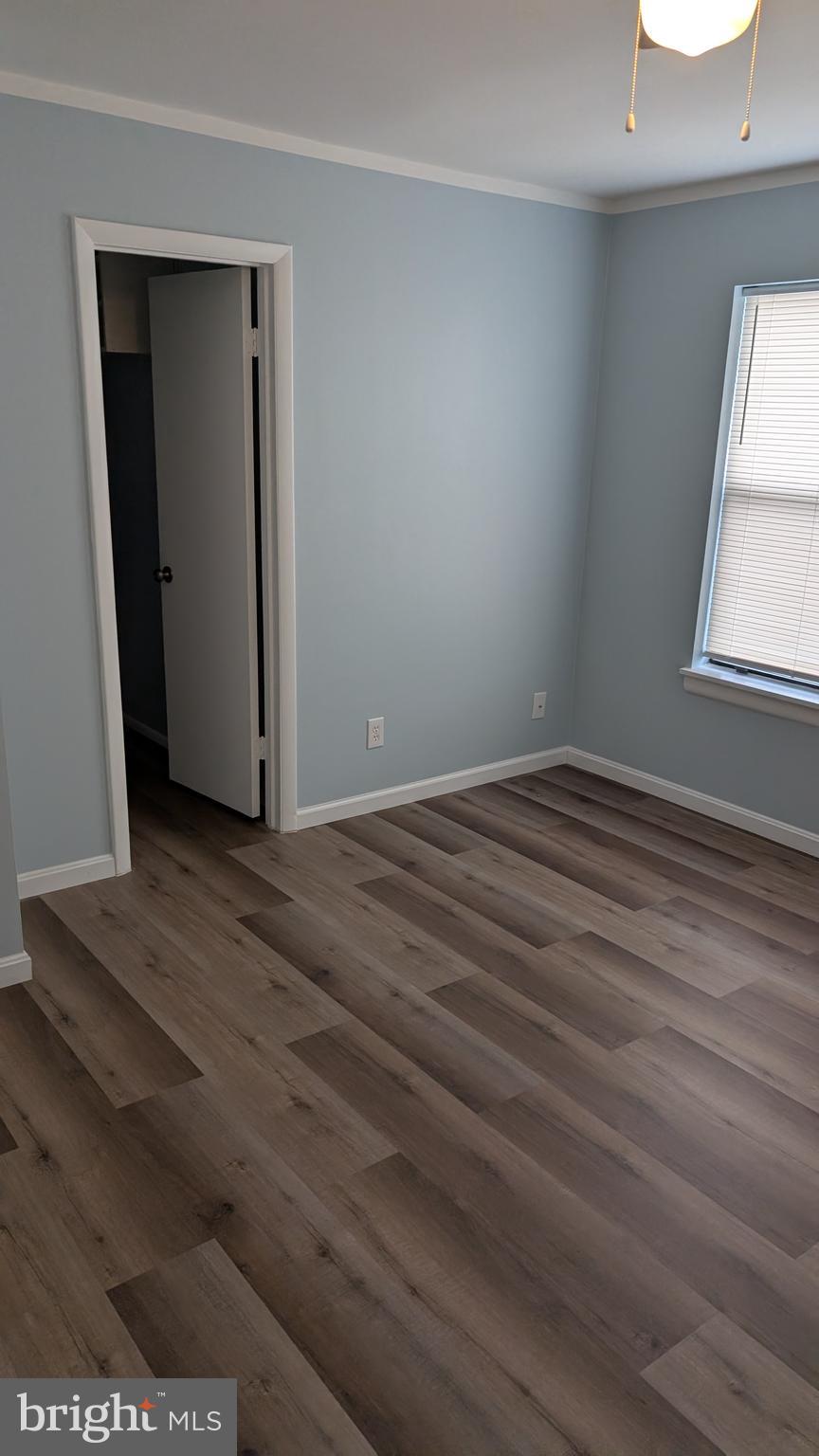 13402 Shady Knoll Drive, Unit 13402 Silver Spring, MD 20904 - Photo 14 of 22 an empty room with wooden floor and windows