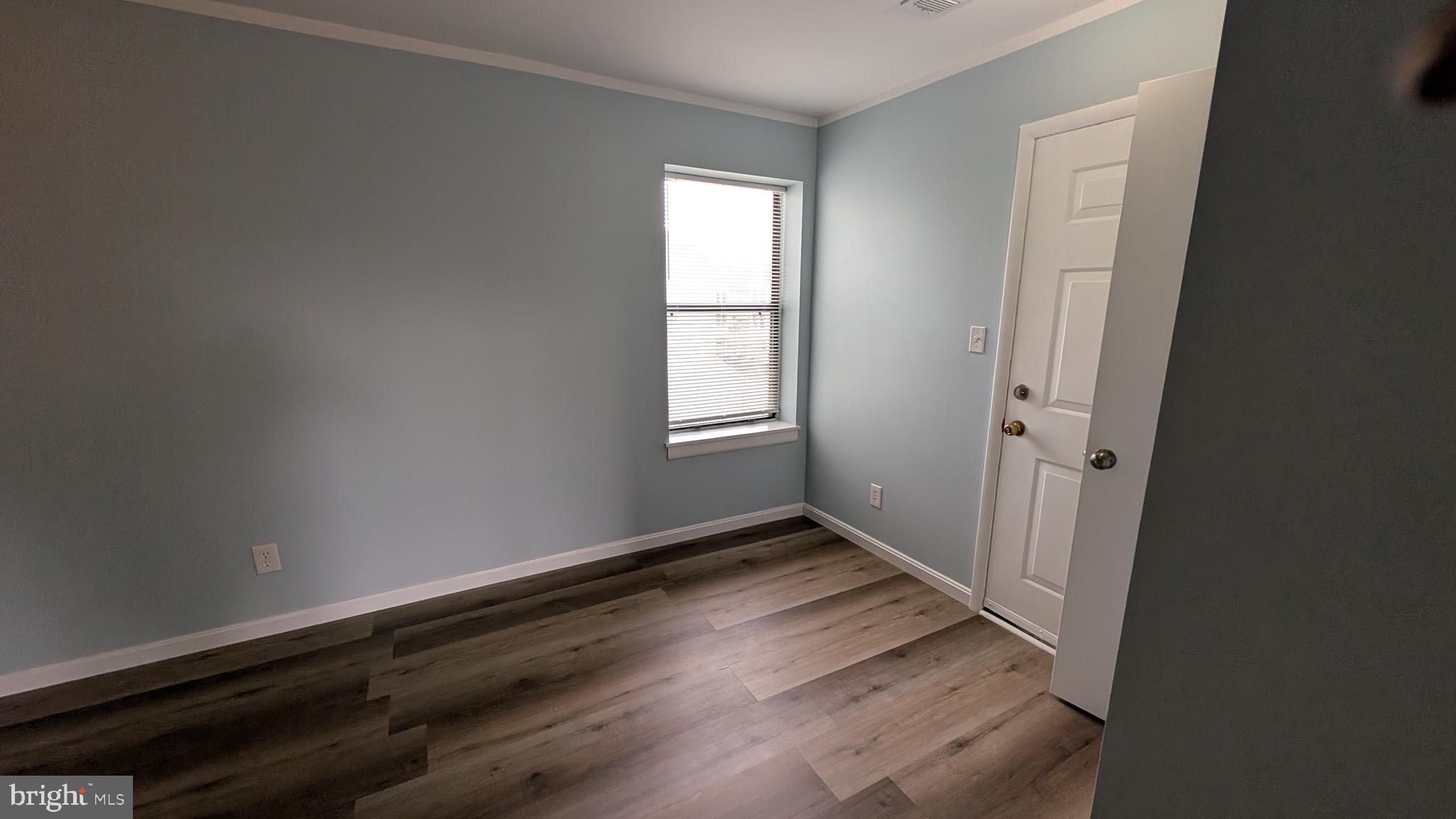 13402 Shady Knoll Drive, Unit 13402 Silver Spring, MD 20904 - Photo 17 of 22 an empty room with wooden floor and windows