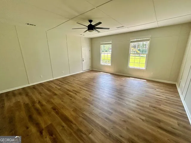 a view of an empty room with wooden floor