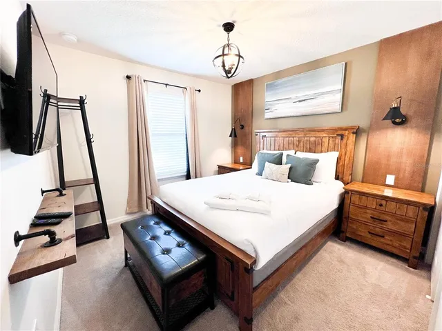 a white bed sitting in a bedroom next to a window