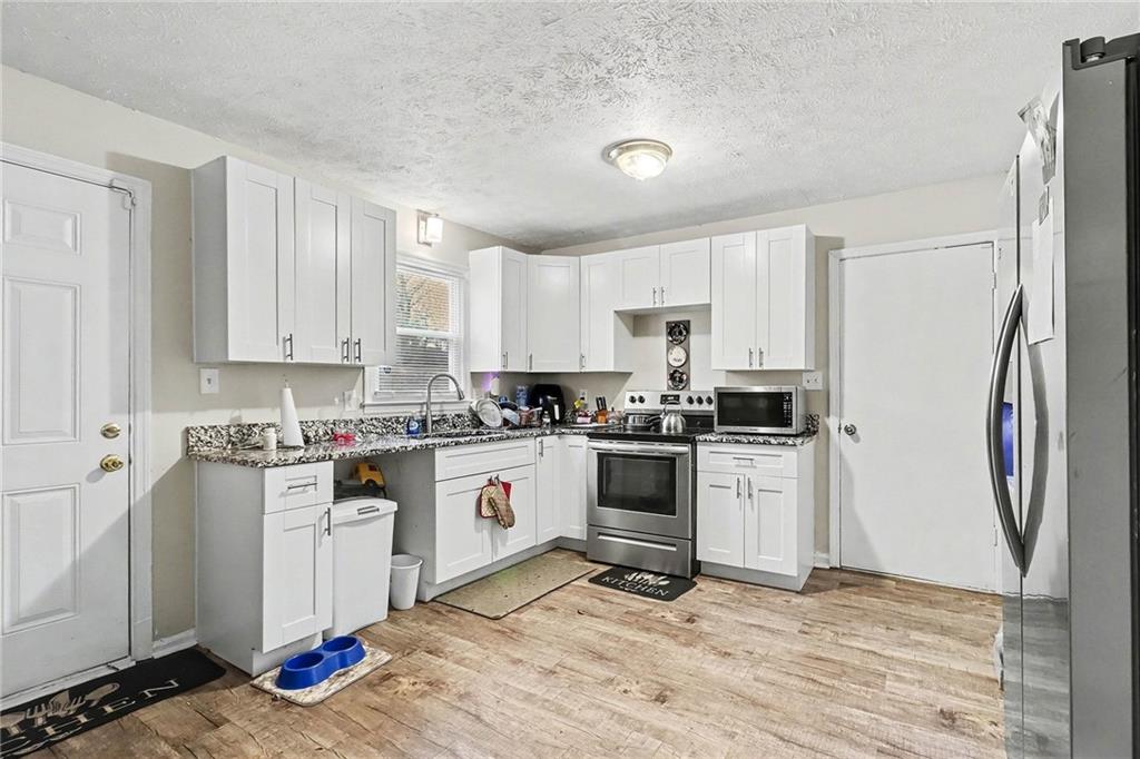 4494 Huntsman Bend Decatur, GA 30034 - Photo 11 of 27 a kitchen with stainless steel appliances granite countertop a stove top oven a refrigerator a sink and dishwasher with white cabinets