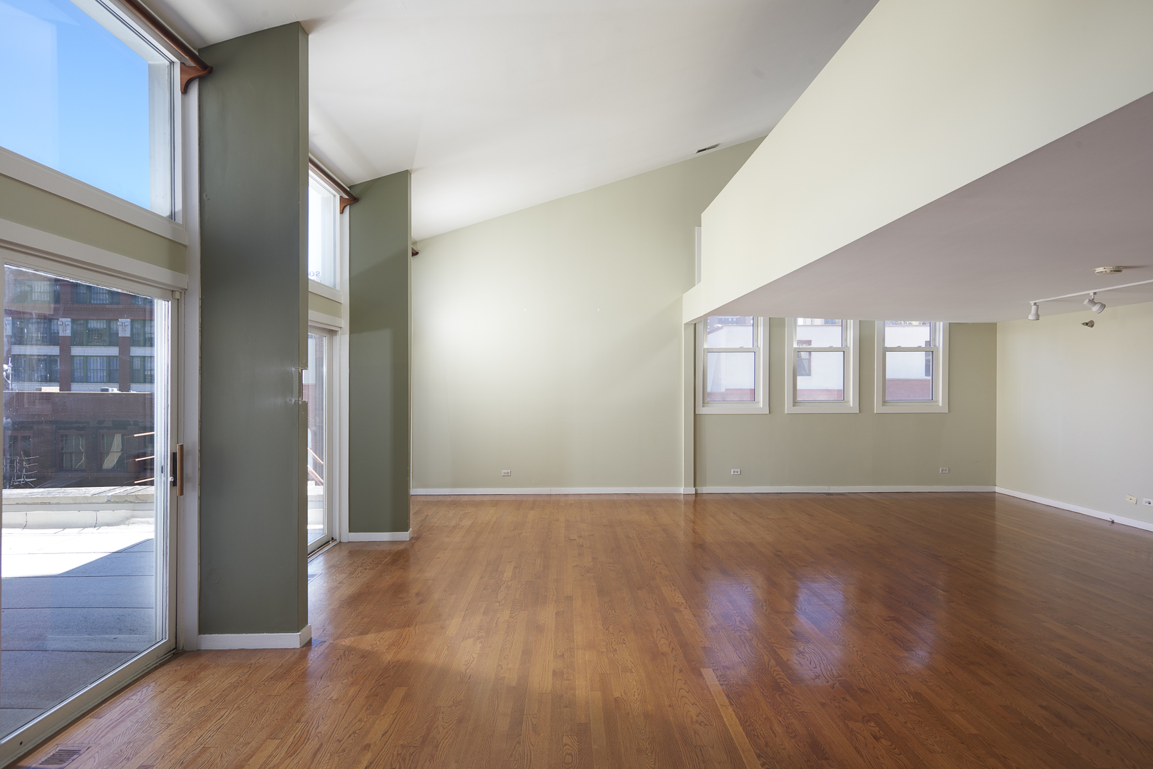 714 South Dearborn Street, Unit 9PH Chicago, IL 60605 - Photo 4 of 26 a view of an empty room with wooden floor and a window
