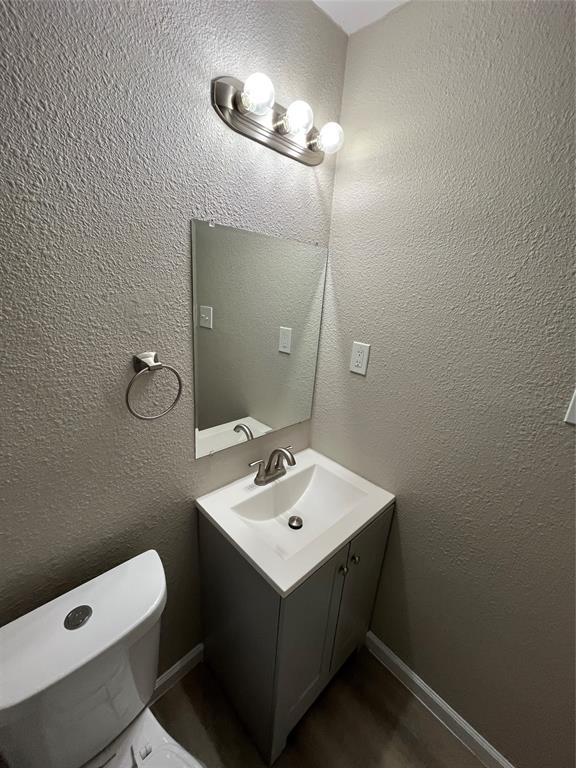 7642 Maxwell Avenue Dallas, TX 75217 - Photo 12 of 20 Bathroom featuring a textured wall and vanity