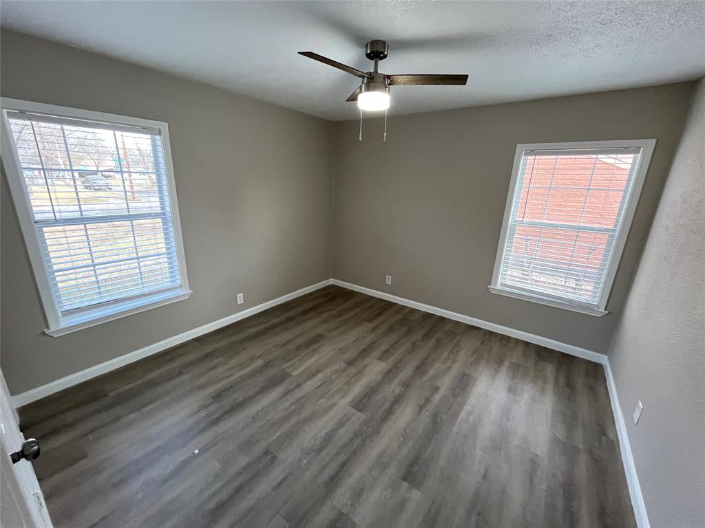 7642 Maxwell Avenue Dallas, TX 75217 - Photo 15 of 20 Empty room with dark wood-type flooring, a textured ceiling, and ceiling fan