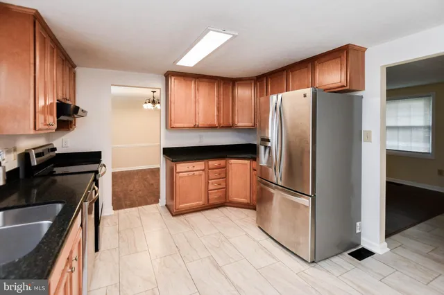 a kitchen with granite countertop stainless steel appliances and wooden cabinets