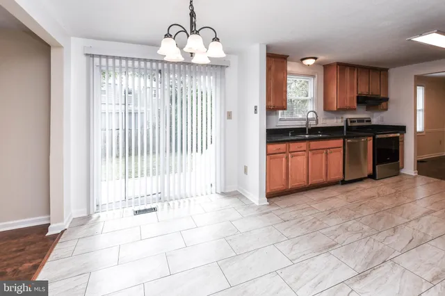 a large kitchen with granite countertop a stove a sink and a refrigerator