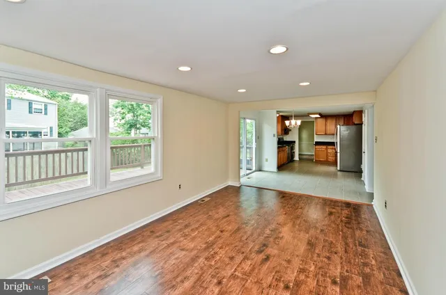 an empty room with wooden floor and a window