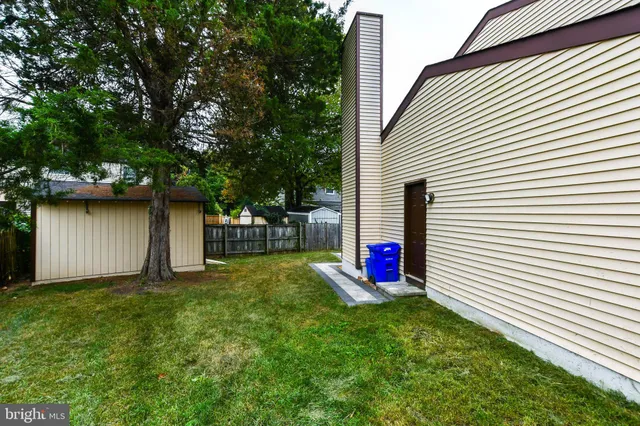 a view of backyard of house with wooden floor and fence