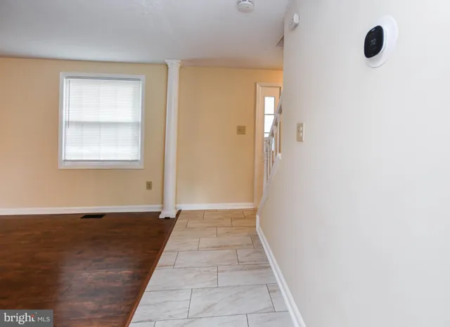 a view of a hallway with wooden floor and a window