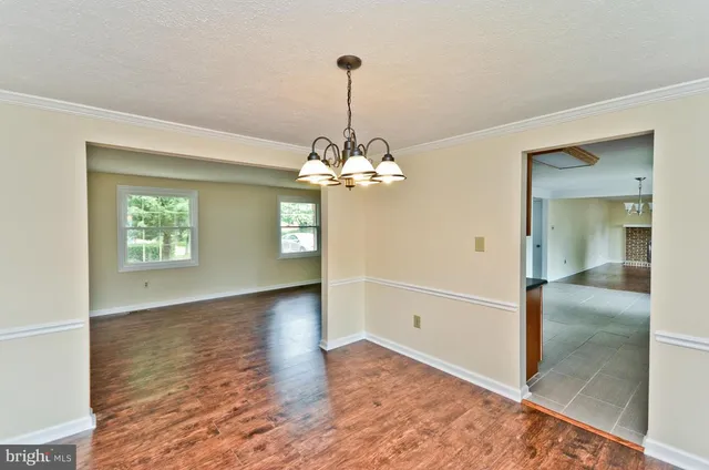 a view of a room with window wooden floor and a chandelier