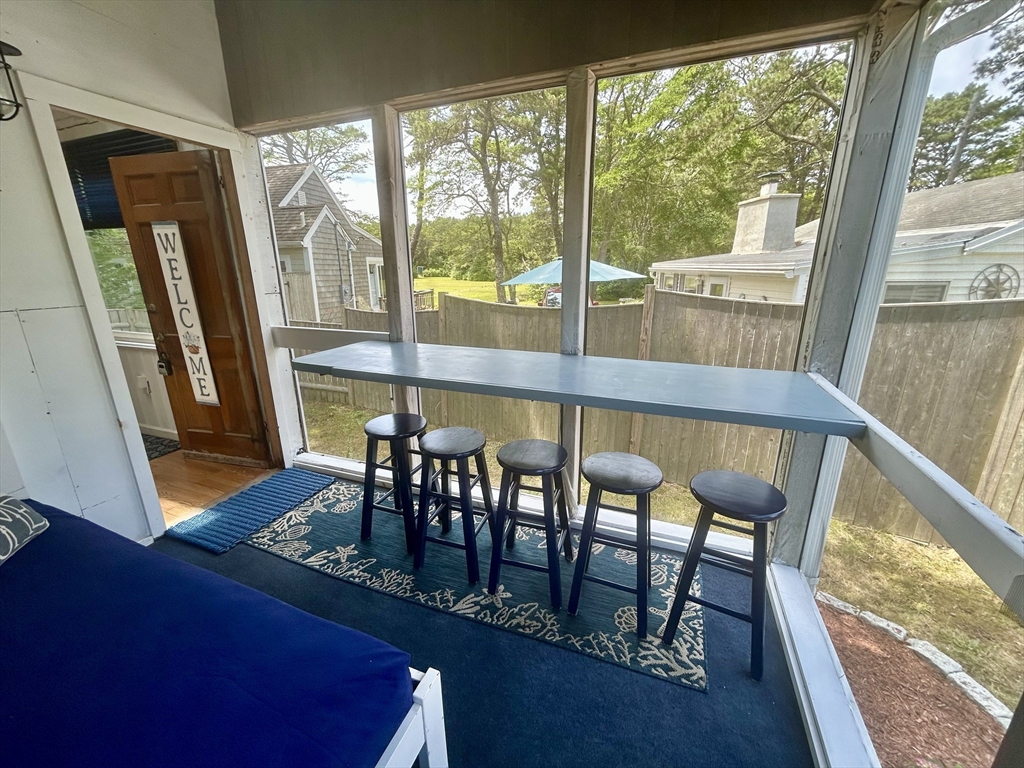 262 Old Wharf Road, Unit 67 Dennis, MA 02639 - Photo 4 of 36 a view of a porch with furniture and wooden floor