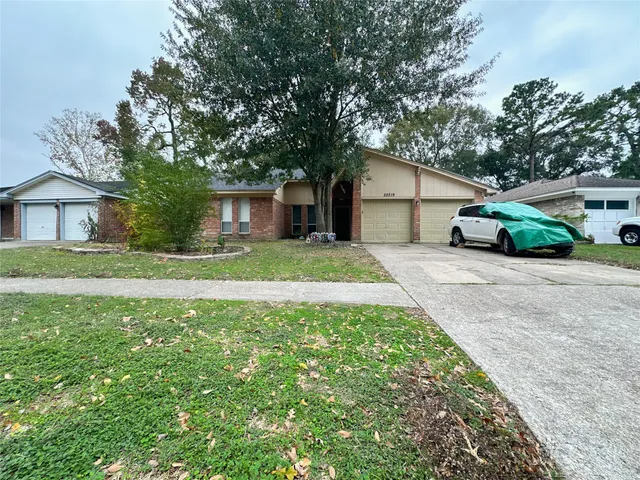 a front view of a house with a garden and trees