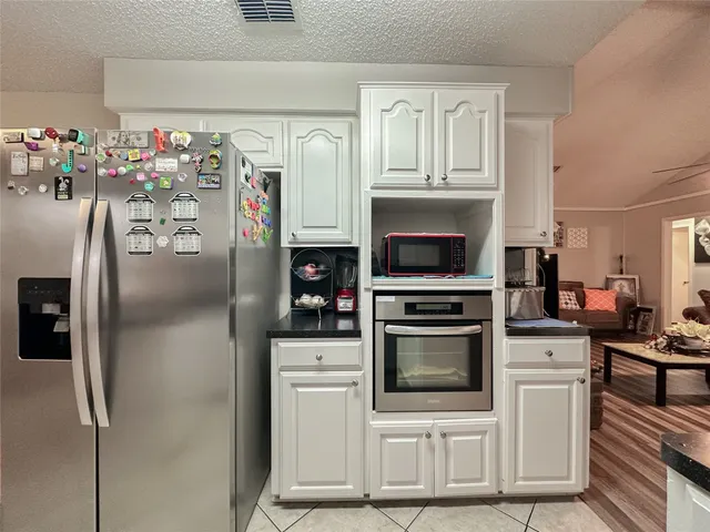 a kitchen with stainless steel appliances a stove a refrigerator and a cabinets