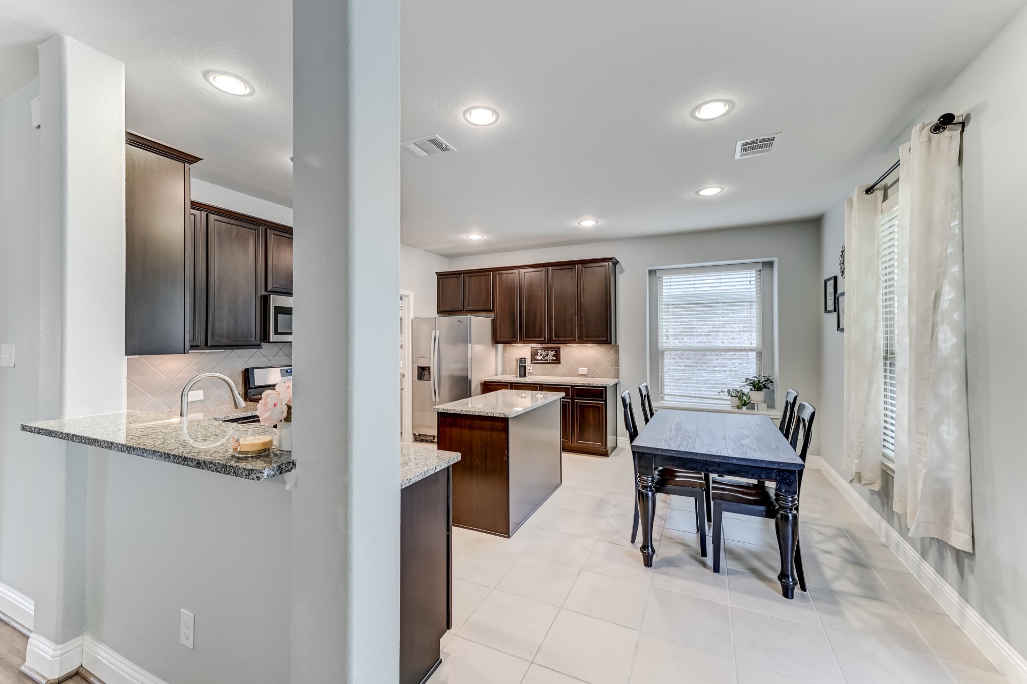 23831 Pennington Hills Drive Spring, TX 77389 - Photo 13 of 46 a kitchen with refrigerator and chairs