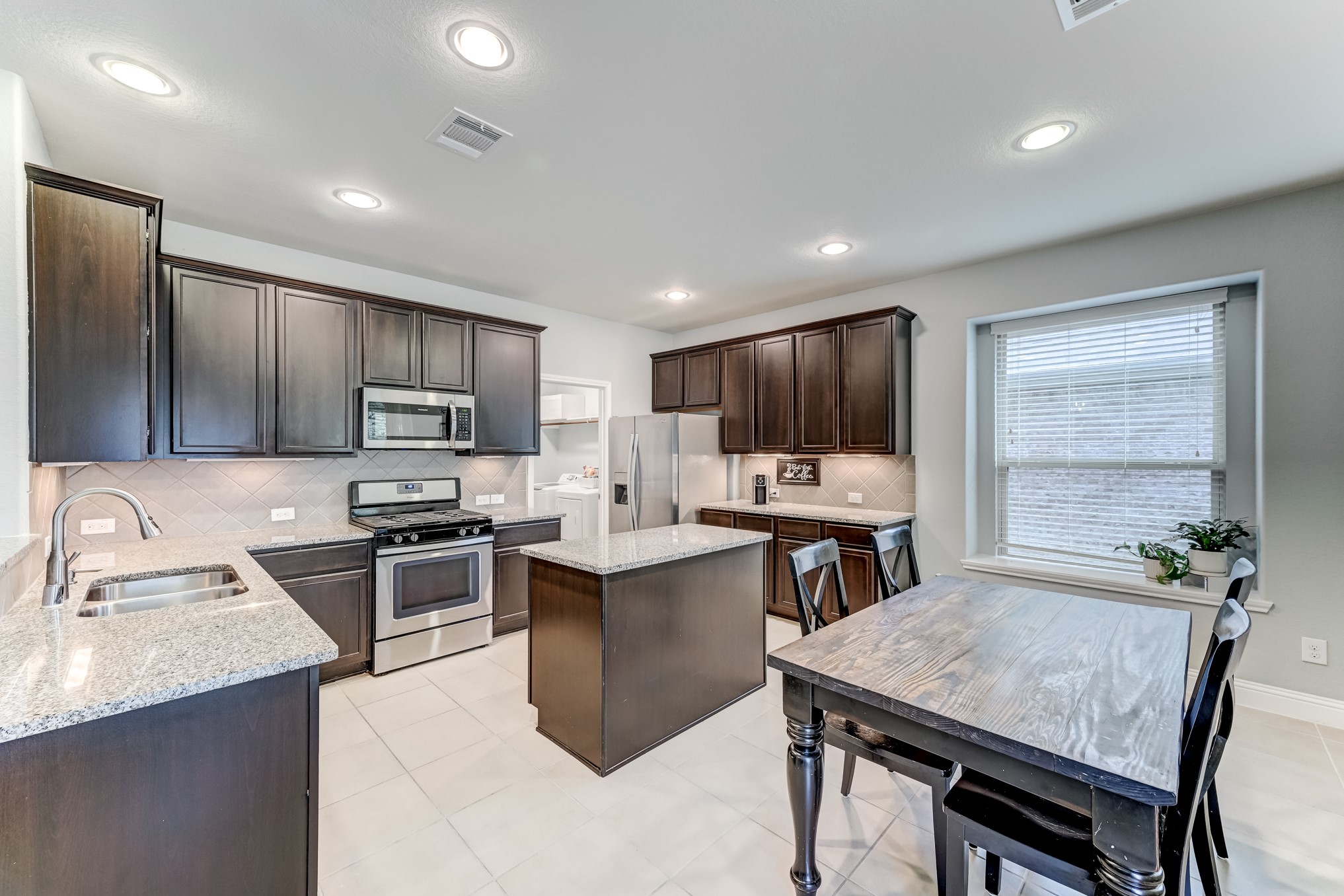 23831 Pennington Hills Drive Spring, TX 77389 - Photo 14 of 46 a kitchen with kitchen island a sink stove and refrigerator