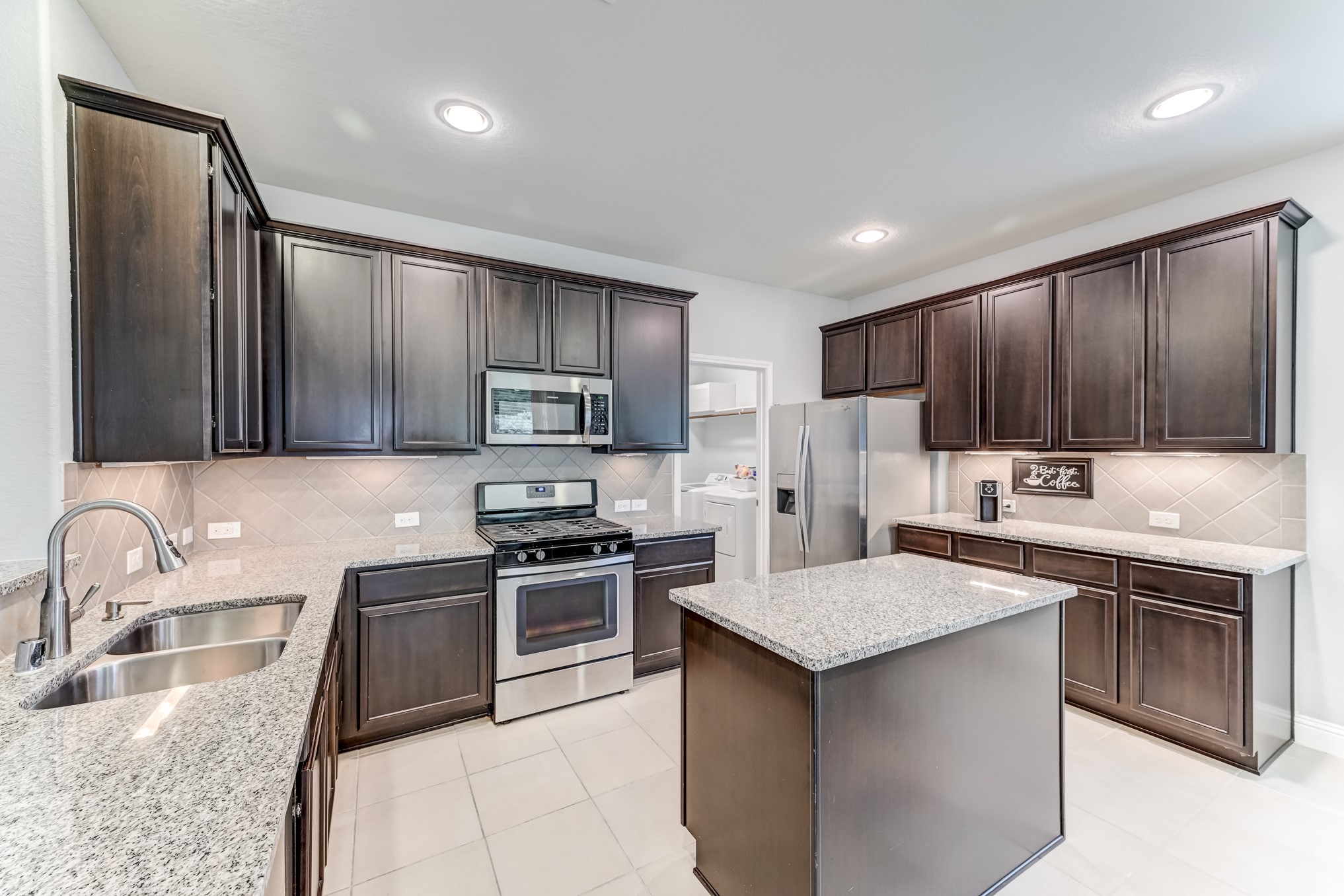 23831 Pennington Hills Drive Spring, TX 77389 - Photo 15 of 46 a kitchen with kitchen island granite countertop stainless steel appliances and sink