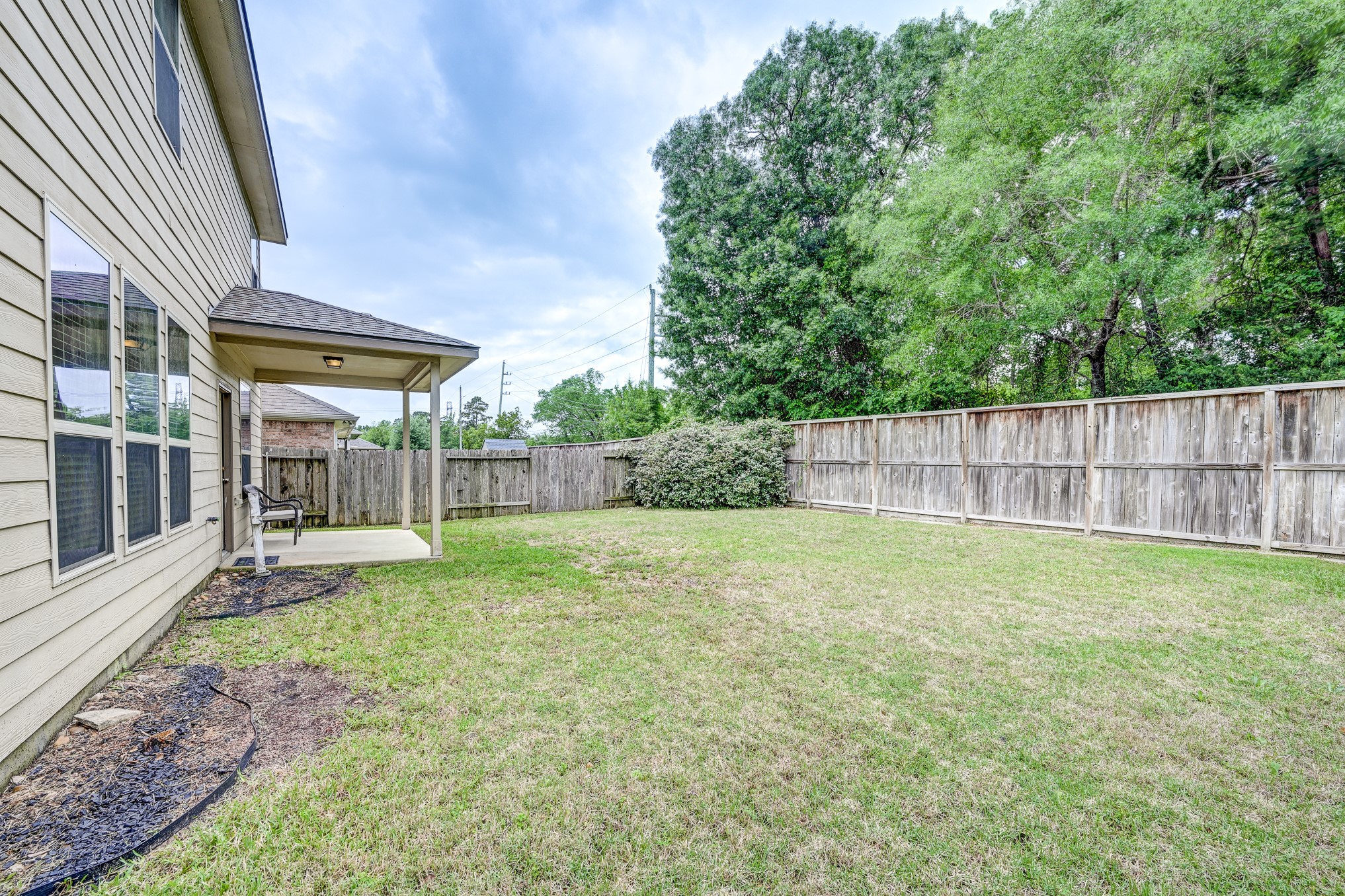 23831 Pennington Hills Drive Spring, TX 77389 - Photo 42 of 46 a view of a yard with a large tree and wooden fence