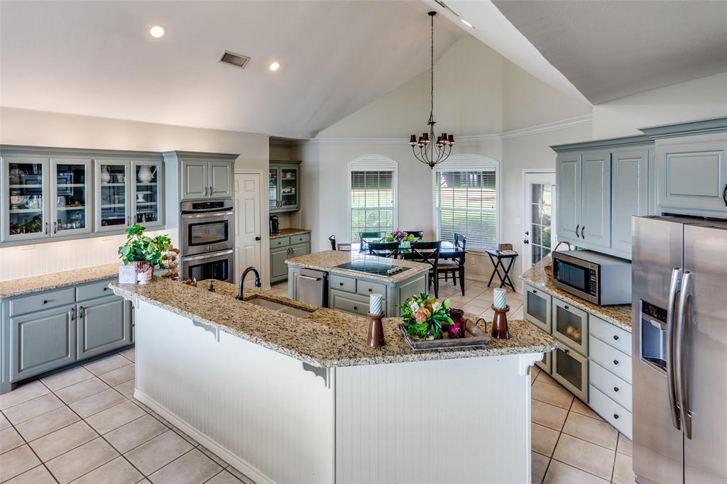 239 Hidden Creek Road Cresson, TX 76035 - Photo 13 of 36 a kitchen with stainless steel appliances granite countertop a sink a stove and a refrigerator