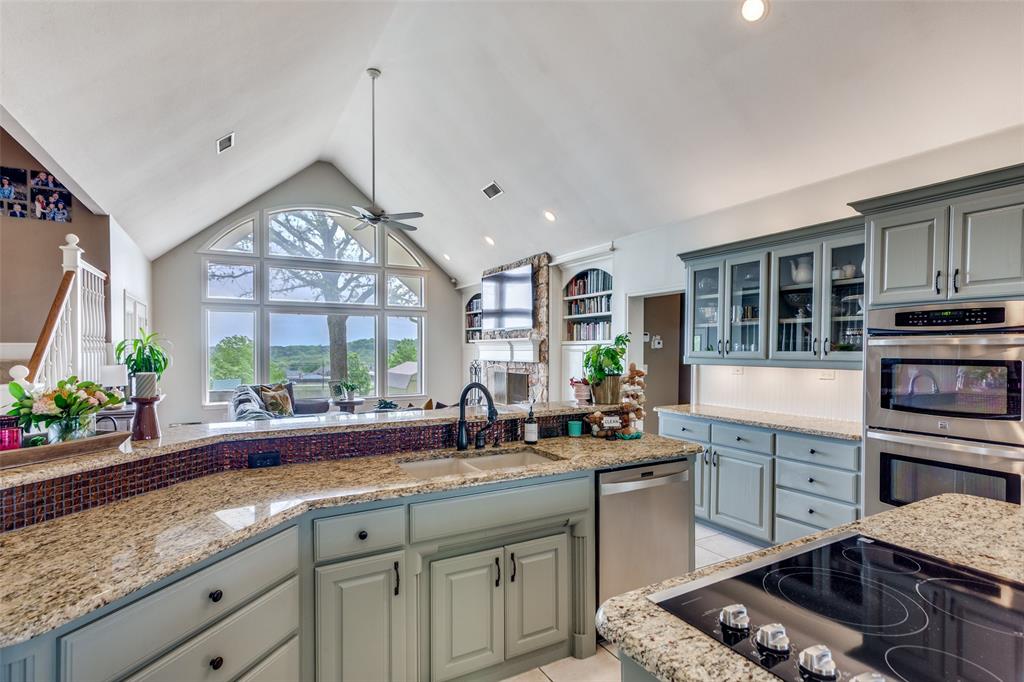 239 Hidden Creek Road Cresson, TX 76035 - Photo 14 of 36 a kitchen with stainless steel appliances granite countertop a stove a sink and a granite counter tops with white cabinets