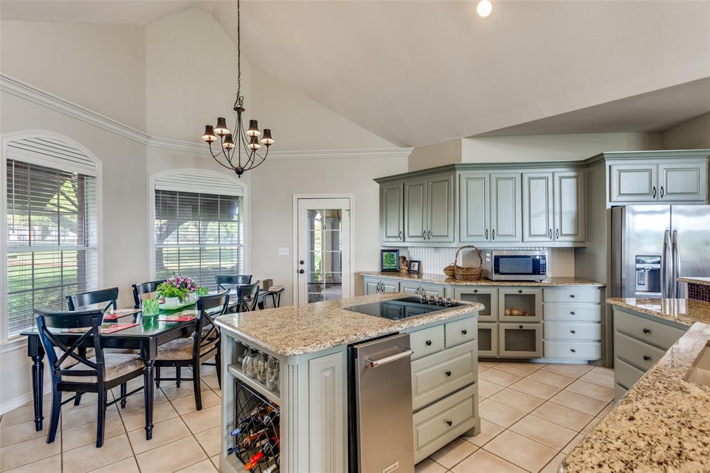239 Hidden Creek Road Cresson, TX 76035 - Photo 15 of 36 a kitchen that has a lot of cabinets in it and wooden floors