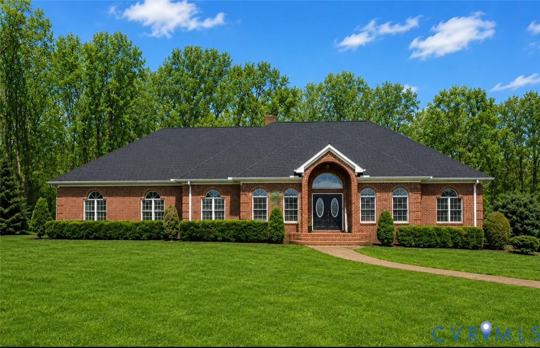 Brick exterior featuring a gabled entryway with ar