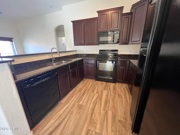 a kitchen with granite countertop a sink stove and cabinets