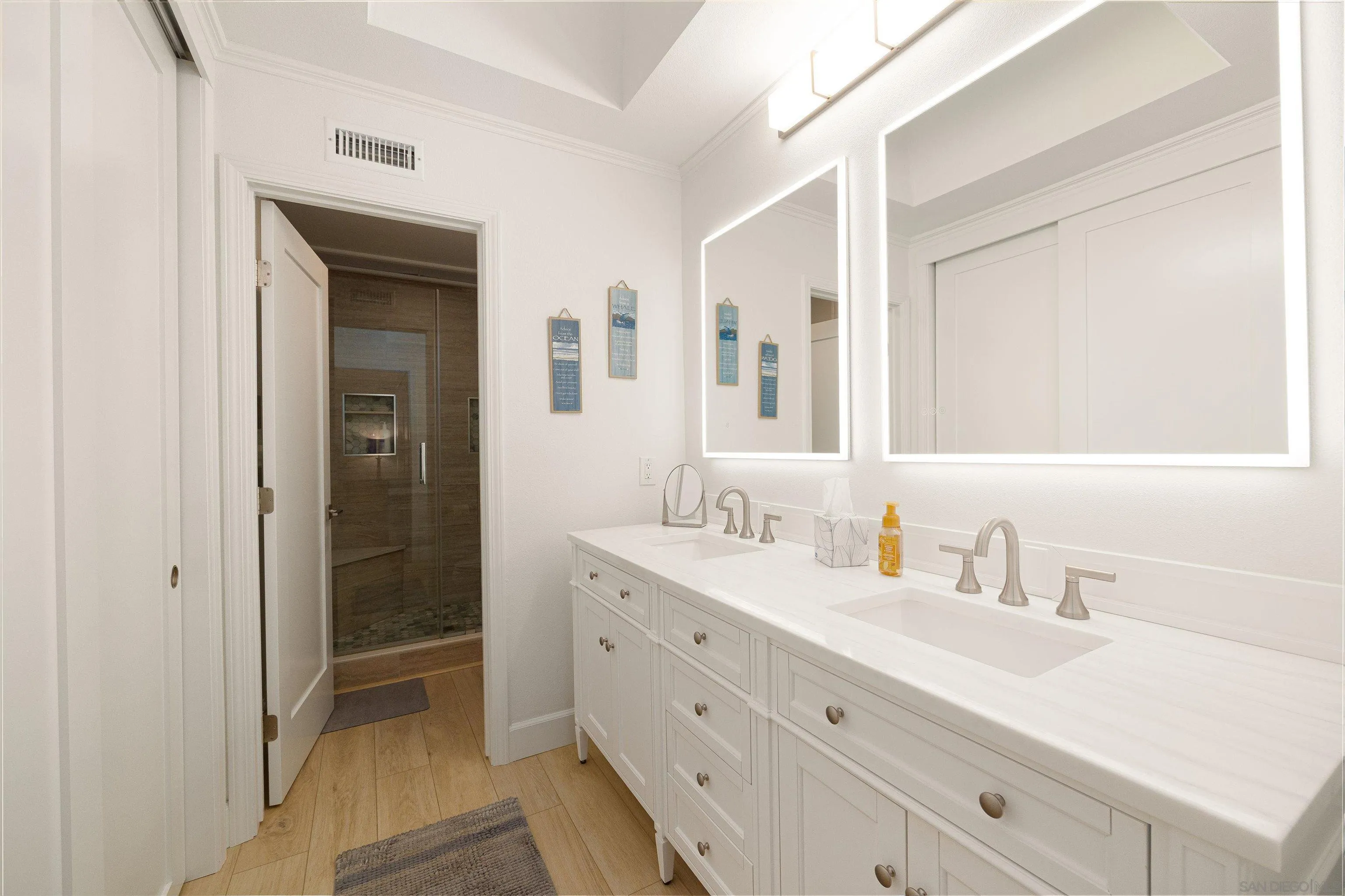 5611 Adobe Falls Road, Unit A San Diego, CA 92120 - Photo 11 of 30 a bathroom with double vanity sink a mirror and a shower