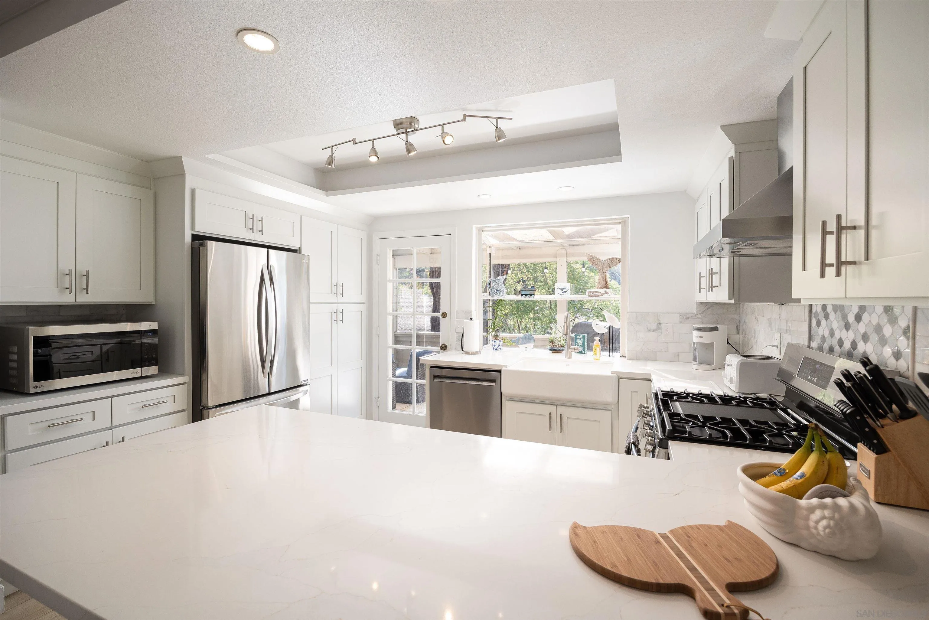 5611 Adobe Falls Road, Unit A San Diego, CA 92120 - Photo 5 of 30 a large white kitchen with a stove a refrigerator and a sink